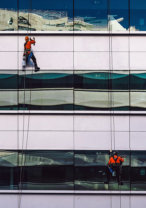 Two men on ropes cleaning windows